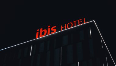  Almaty, Kazakistan - 18 Ocak 2025: Binanın çatısındaki Ibis Oteli ışıklı tabela. Gece vakti.                              