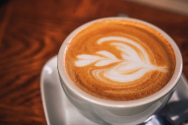 Köpük yüzeyinde bir deseni olan kahve kupası. Tüketici kültürü                    