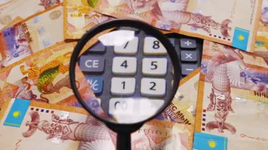 Onluk banknotlar ve hesap makinesi düğmeleri büyüteç görüntüleme altında. Mali kontrol. Muhasebe raporu
