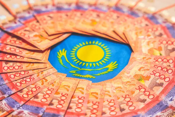 Katlanmış tenge banknotları çemberinde Kazakistan bayrağının sembolleri. Devlet finansmanı                         