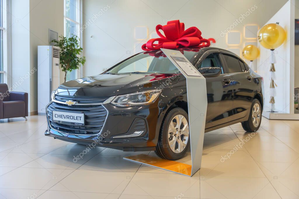 Almaty, Kazakhstan - June 11, 2025: Black Chevrolet Onix with a gift bow on the roof. American automobile brand. Official dealership