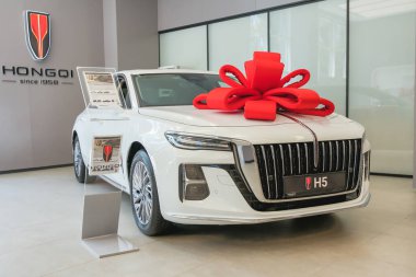 Almaty, Kazakistan - 11 Haziran 2025: beyaz araba Hongqi H5 ve hediye yayı sergi salonunda. Çinli otomobil üreticisi                              