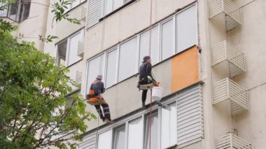 Almaty, Kazakistan - 14 Temmuz 2025: Bir binanın cephesini boyayan tırmanışçılar. Yüksek irtifa çalışması