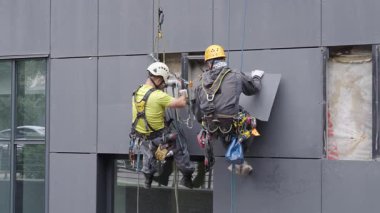 Almaty, Kazakistan - 14 Temmuz 2025: Bir binanın ön cephesini tamir eden dağcılar. Yüksek irtifa çalışması