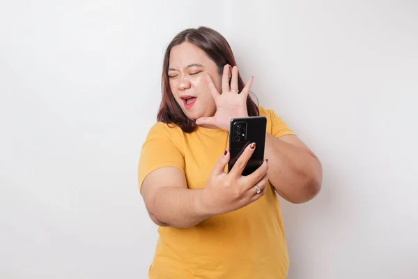 Розгніване Божевільне Обличчя Великої Азіатки Жовтій Сорочці Тримаючи Телефон Ізольованому — стокове фото
