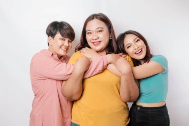 Mutlu üç yakın arkadaş birbirine sarılıp dostça bir jest yapıyor.