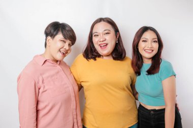 Üç arkadaşın portresi gülümsüyor, beyaz arka planla izole edilmiş mutlu duyguları ifade ediyor.