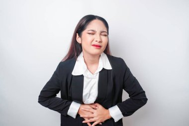 Karnı ağrıyan, ofiste çok çalışan genç bir iş kadını. Gastrit, hazımsızlık ya da kabızlık konsepti