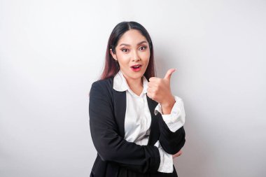 Siyah takım elbiseli heyecanlı Asyalı iş kadını, beyaz arka planla izole edilmiş bir şekilde el hareketini onaylıyor.