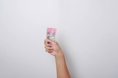 Endonezya Rupia 'sında bir avuç parayı tutan bir el portresi.