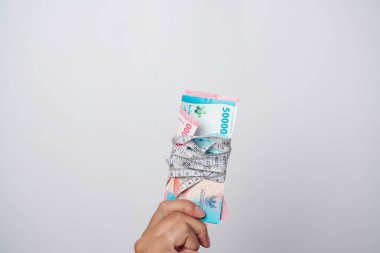 Endonezya rupiası bir mezura ile bağlanmış. Para ölçme konsepti. Finansal yatırımların büyüklüğü, gelir miktarı.