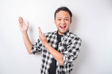 Asyalı gülümseyen adam beyaz arka planla izole edilmiş, üzerindeki fotokopi alanını işaret ediyor.