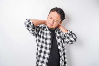 Acı çeken, iş yerinde kas spazmı geçiren yorgun genç bir adam. Yorgunluk, teslim tarihi, acı ve yanlış duruş