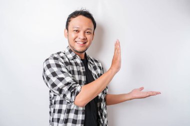 Asyalı heyecanlı adam beyaz arka planla izole edilmiş, yanındaki fotokopi odasını işaret ediyor.