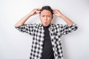 Asyalı stresli bir adamın beyaz arkaplanla izole edilmiş ekose gömlek giymiş portresi depresif görünüyor.