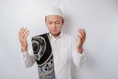 Omzunda dua halısı olan yakışıklı Asyalı Müslüman adam Tanrı 'ya dua ediyor..