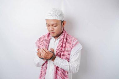 Asyalı yakışıklı Müslüman adam Tanrı 'ya dua ediyor..