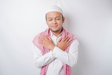 Barışçıl Asyalı Müslüman bir adamın portresi gülümsüyor ve rahatlıyor.