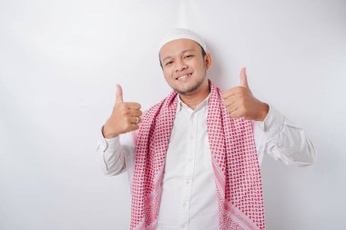 Heyecanlı Asyalı Müslüman adam beyaz arka planla izole edilmiş bir şekilde el hareketi yapıyor.