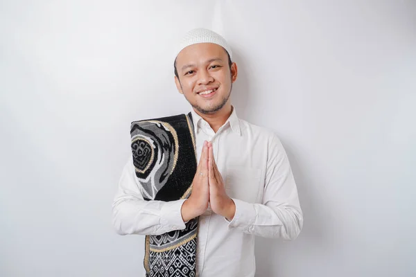 笑顔若いアジアのイスラム教徒の男とともに祈りの敷物彼の肩に ジェスチャー伝統的な挨拶隔離された白い背景 — ストック写真