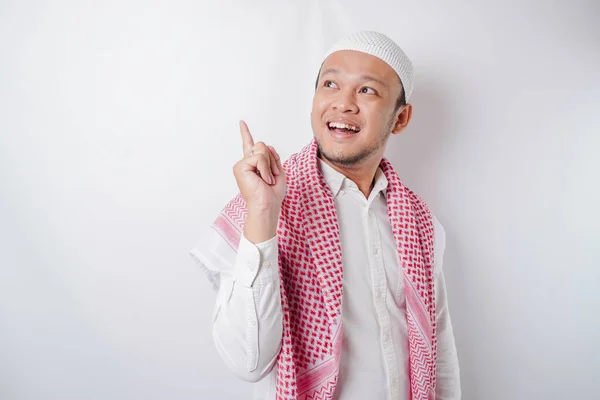 Aufgeregter Asiatischer Muslim Zeigt Auf Den Kopierraum Neben Ihm Isoliert — Stockfoto