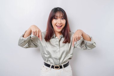 Heyecanlı Asyalı, yeşil tişörtlü, beyaz arka planla izole edilmiş fotokopi odasını gösteren bir kadın.