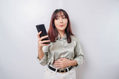 Aç, heyecanlı, genç bir kadının elinde telefonu olan fotoğrafı ve beyaz arka planda ne sipariş edeceğini merak eden nefis yemekler.
