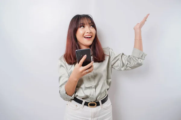 Podekscytowana Azjatka Szałwiowym Zielonym Garniturze Wskazująca Miejsce Ksero Trzymając Telefon — Zdjęcie stockowe