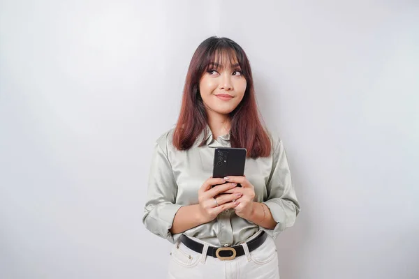 Zdjęcie Przemyślanej Młodej Kobiety Trzymającej Telefon Patrzącej Bok Odizolowana Białym — Zdjęcie stockowe