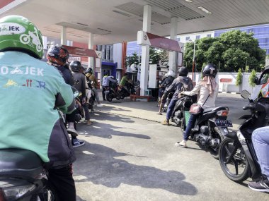 Bir sıra insan, Endonezya 'daki yerel bir benzin istasyonunda araçlarına benzin veya dizel doldurmak için toplanıyor.