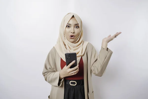 Zszokowana Azjatka Hidżabie Wskazująca Miejsce Którym Trzyma Telefon Odizolowana Białym — Zdjęcie stockowe