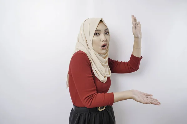 stock image Shocked Asian woman wearing hijab pointing at the copy space beside her, isolated by white background