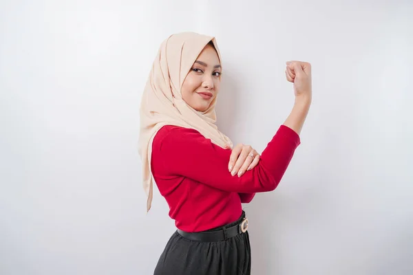興奮アジアのイスラム教徒の女性は彼女の腕と筋肉を持ち上げることによって強いジェスチャーを示すヒジャーブを身に着けている誇らしげに微笑む — ストック写真