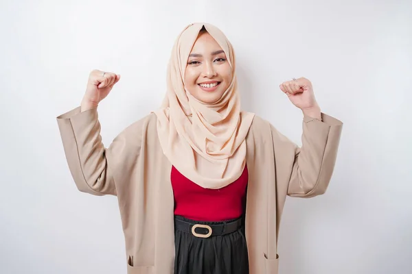 興奮アジアのイスラム教徒の女性は彼女の腕と筋肉を持ち上げることによって強いジェスチャーを示すヒジャーブを身に着けている誇らしげに微笑む — ストック写真