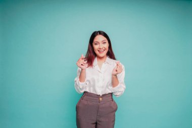 Beyaz gömlek giyen mutlu, genç bir Asyalı kadın romantik bir şekil alır. Kalp hareketi şefkatli duygular ifade eder.