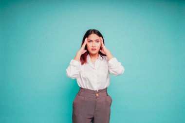 Mavi arka planda izole edilmiş beyaz gömlek giyen Asyalı bir kadının portresi depresif görünüyor.