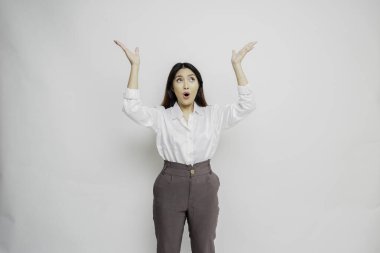 Beyaz gömlekli, beyaz tişörtlü, beyaz arkaplan tarafından izole edilmiş, üzerindeki fotokopi alanını gösteren Asyalı kadın şok oldu.