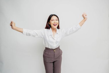 Mutlu ve başarılı bir yüzü olan beyaz gömlek giyen genç bir Asyalı kadın beyaz arka planda izole edilmiş.