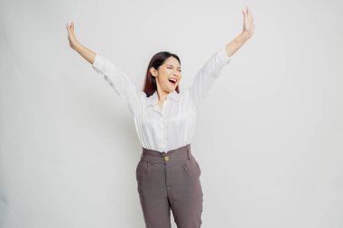 Mutlu ve başarılı bir yüzü olan beyaz gömlek giyen genç bir Asyalı kadın beyaz arka planda izole edilmiş.