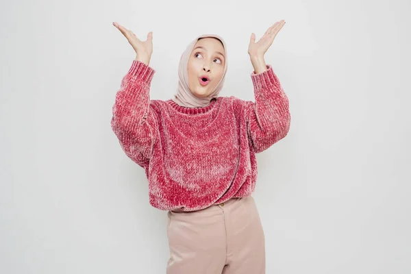 ピンクのセーターとヒジャーブを着た衝撃的なアジアのイスラム教徒の女性が彼女の上にコピースペースを指して 白い背景によって隔離されました — ストック写真