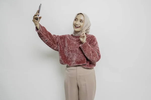 Портрет Счастливой Азиатки Розовом Свитере Хиджабе Держащей Телефон Изолированный Белым — стоковое фото