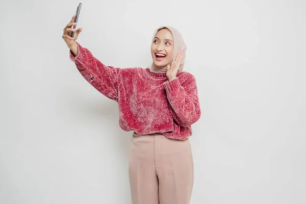 Портрет Счастливой Азиатки Розовом Свитере Хиджабе Держащей Телефон Изолированный Белым — стоковое фото