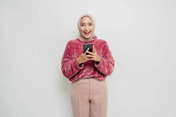 Portret Szczęśliwej Azjatki Różowym Swetrze Hidżabie Trzymającej Telefon Odizolowanej Białym — Zdjęcie stockowe