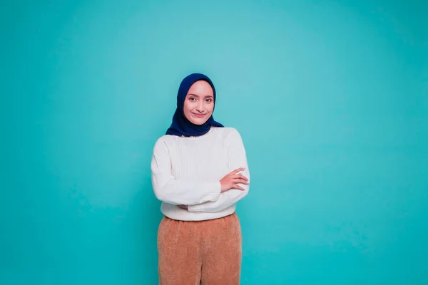 一个自信微笑的亚洲穆斯林女人的画像 她身穿白衬衫 头戴头巾 双手交叉地站在一起 凝视着蓝色背景下被隔离的相机 — 图库照片