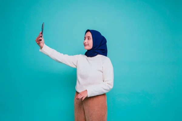 셔츠와 히잡을 착용하고 배경에 고립된 휴대폰을 아시아 이슬람 여성의 — 스톡 사진