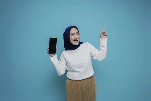 셔츠를 히잡을 흥분한 아시아 이슬람 자신의 복제품 공간을 가리키며 핸드폰 — 스톡 사진