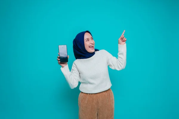 셔츠를 히잡을 흥분한 아시아 이슬람 자신의 복제품 공간을 가리키며 핸드폰 — 스톡 사진