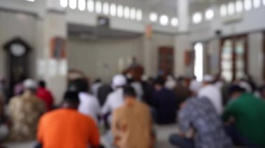 Bulanık arkaplan İslamcı erkekler cuma günü camide namaz kılıyor. Camide toplanıyorlar.. 