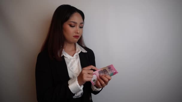 Zmieszana Młoda Bizneswoman Nosi Czarny Garnitur Trzyma Pieniądze Rupii Indonezyjskiej — Wideo stockowe