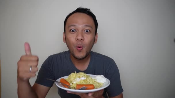 幸せと興奮の表情でインスタントラーメンを食べる若いアジア人男性 — ストック動画